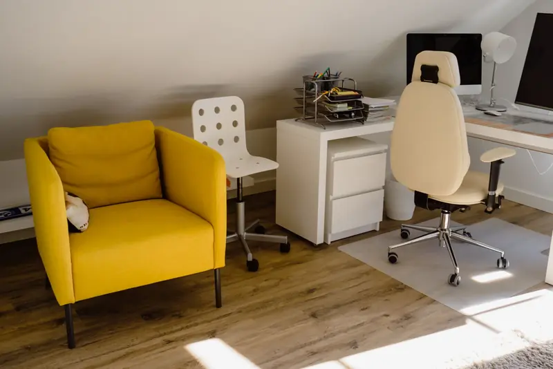 Bright home office with a yellow chair and organized desk setup