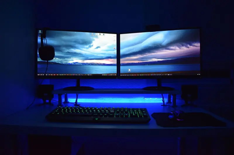 Dual monitors with blue lighting on a gaming desk setup