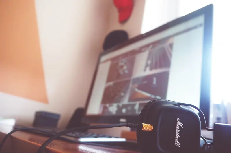 A contemporary desk setup featuring headphones and a computer screen displaying digital content