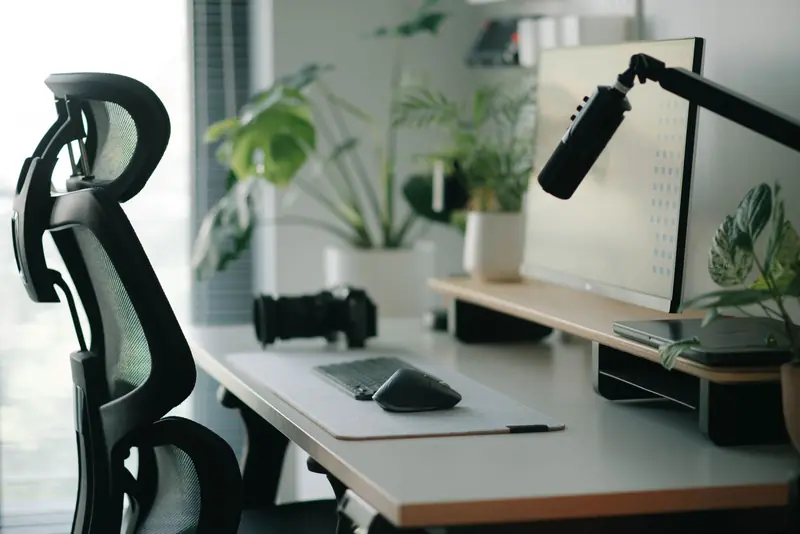 Stylish home office setup with ergonomic chair, plants, and tech accessories creating a modern work environment