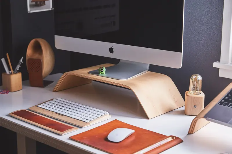 Sleek modern home office desk with computer, wooden accessories, and organized workspace