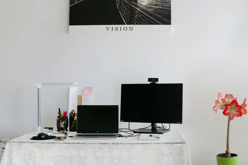 Stylish home office with laptop, monitor, and modern decor on a white desk